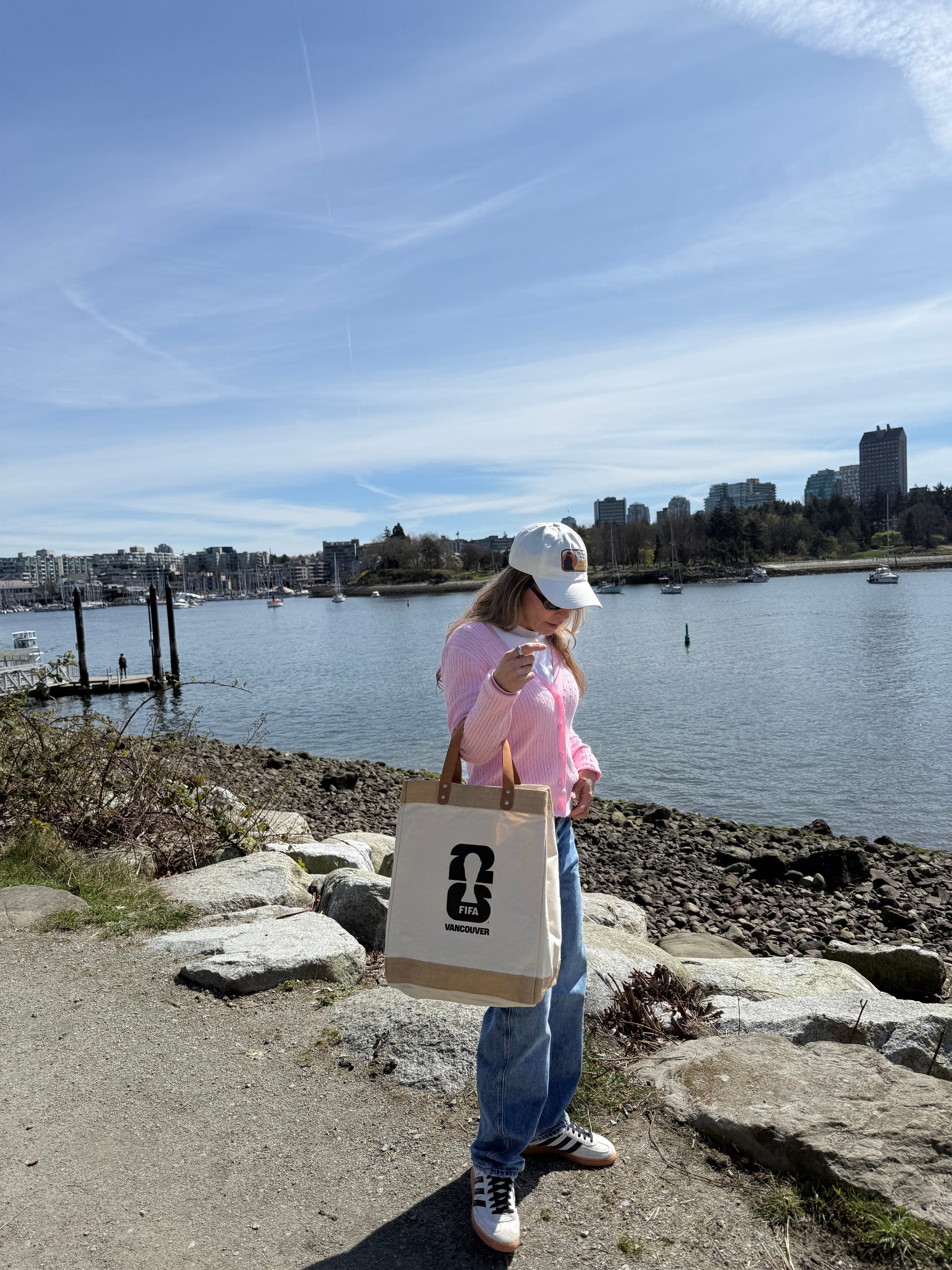 Person holding a canvas market bag with FIFA Vancouver logo on it